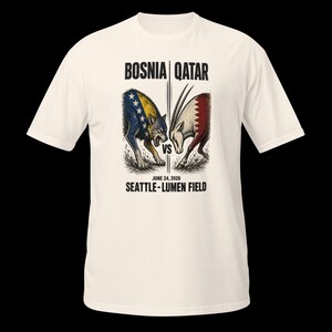 May include: Off-white t-shirt with a graphic depicting a wolf and an oryx, symbolizing Bosnia versus Qatar. The text "BOSNIA | QATAR" and "JUNE 24, 2026 SEATTLE - LUMEN FIELD" are printed above and below the illustration.