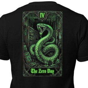 May include: Black t-shirt featuring a green illustration of a snake with the text "The Zero Day" and the Roman numeral "IV". The snake is depicted with its mouth open, dripping with a green substance, set against a backdrop of a building.