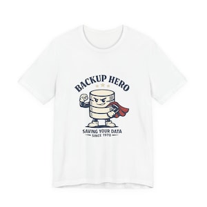 May include: White t-shirt with a cartoon database character in a superhero pose. The design includes the text "BACKUP HERO" above the character and "SAVING YOUR DATA SINCE 1970" below. The character is wearing a red cape.