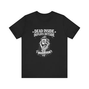 May include: Black t-shirt with a white graphic. The graphic features the text "DEAD INSIDE DEPLOYS OUTSIDE" above a skeleton hand holding a coffee mug with the text "DBA FUEL". A banner below reads "production approves".