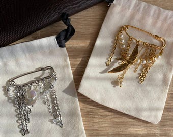 Broche de oro con forma de imperdible y perlas