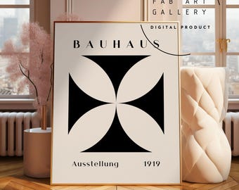 May include: A framed Bauhaus art print with a black and cream geometric design. The print features the word "BAUHAUS" at the top, with "Ausstellung 1919" at the bottom. The print is displayed on a wooden floor.