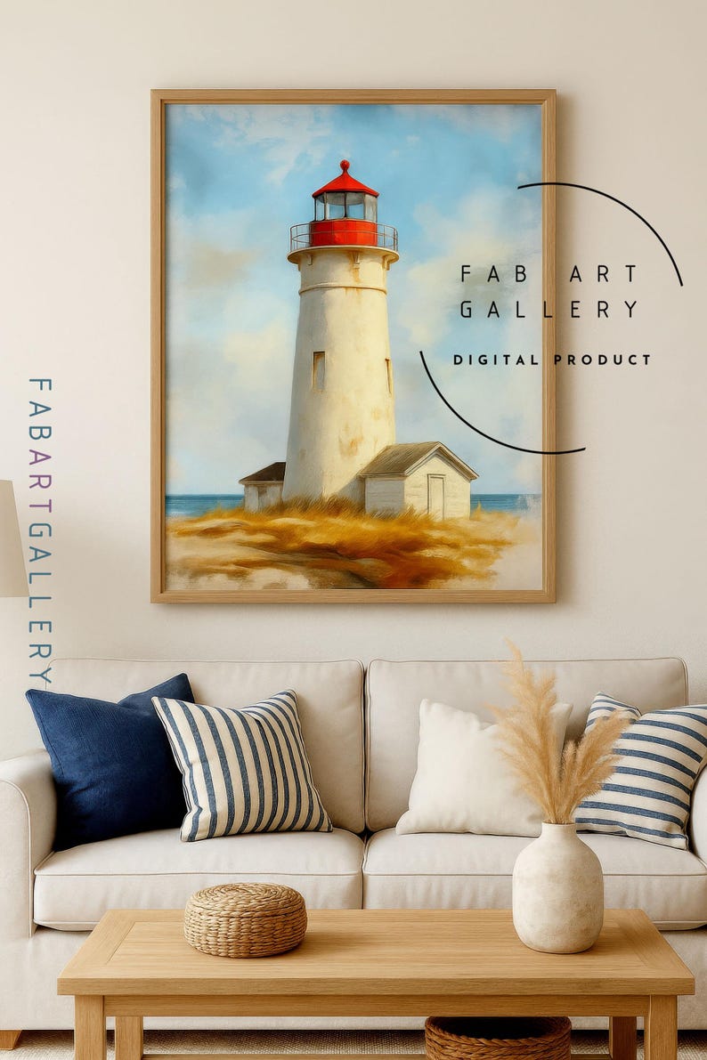 May include: A framed print of a lighthouse with a red top and white tower, set against a blue sky and ocean. The artwork is labeled "FAB ART GALLERY DIGITAL PRODUCT". The print is displayed above a white sofa with blue and striped pillows.