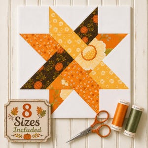 May include: A square quilt block featuring a star pattern in shades of orange, yellow, and brown with floral and pumpkin prints. A sign reads 8 Sizes Included. A pair of metal scissors and two spools of Gütermann thread in orange and green are present.