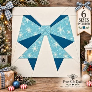 May include: A square quilt block featuring a large central bow design constructed from light blue fabric with white snowflake patterns and solid dark blue accents, set against a white background. A wooden tag reads 6 SIZES INCLUDED.