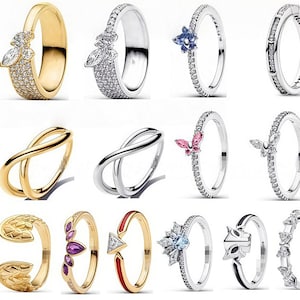 Può includere: Una collezione di anelli vari, che presentano diversi design. Gli anelli presentano tonalità oro e argento, adornati con pietre preziose, cristalli e forme uniche, tra cui farfalle, simboli dell'infinito e motivi geometrici. Alcuni anelli hanno dettagli intricati.