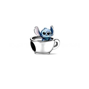Może przedstawiać: Srebrny charms przedstawiający postać Stitcha z Lilo & Stitch, wychylającego się ze srebrnego kubka. Charms ma szczeg&oacute;łowy design z błyszczącym wykończeniem. Kubek ma uchwyt i otw&oacute;r z boku. Jest to przedmiot kolekcjonerski.