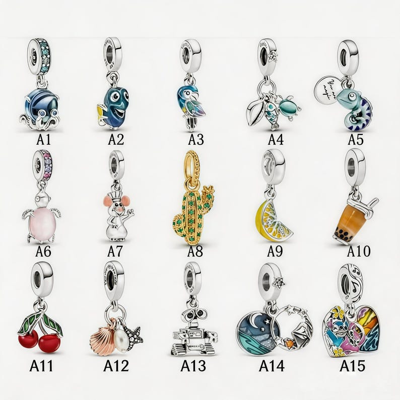 Pu&ograve; includere: Una collezione di ciondoli in argento con vari design, tra cui un pesce, un pesce chirurgo blu, un pappagallo, un'ape con una tartaruga, un camaleonte, una tartaruga, un topo, un cactus, una fetta di limone, un bubble tea, ciliegie, una conchiglia con una perla e stella marina, un robot, una luna e stelle e un personaggio colorato.