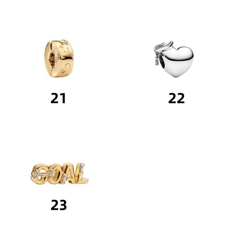 May include: Three jewelry charms labeled 21, 22, and 23. Number 21 is a gold-toned cylindrical charm with star engravings and small stones. Number 22 is a silver-toned heart charm with a graduation cap. Number 23 is a gold-toned charm spelling GOAL.