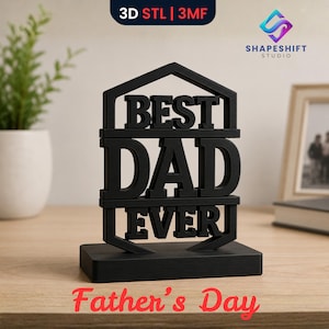 May include: A black 3D-printed sign that reads "BEST DAD EVER" in bold, block letters. The sign is in a house-shaped frame and sits on a rectangular base. The words "Father's Day" are written in red script below the sign.