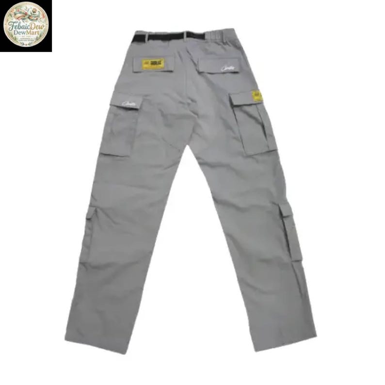 May include: Gray cargo pants with multiple pockets and a black belt. The pants have a relaxed fit and are made of a durable material. Small yellow and white labels are visible on the back pockets. The pants are laid flat on a white background.