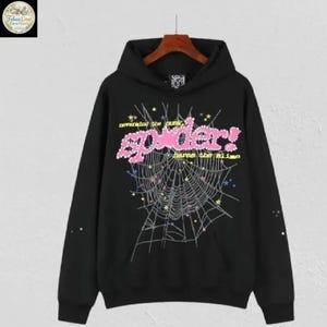May include: Black hoodie with a graphic design featuring a spider web and the word "spider!" in pink, with the text "neverend the punk" above and "harms the slime" below. The design includes stars and other small details.