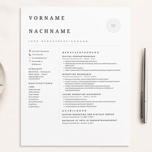 May include: A minimalist resume template in black and white, featuring sections for name, contact information, skills, and experience. A silver pen rests beside the document, with a decorative plate and greenery in the background.