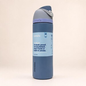 May include: A 24 oz. Owala water bottle in matte blue with a light purple collar and a dark gray lid featuring a built-in straw. The label reads: Hi there. I'm leak proof. I'm insulated. And I have a built-in straw. It also displays 24 oz. (710 mL).