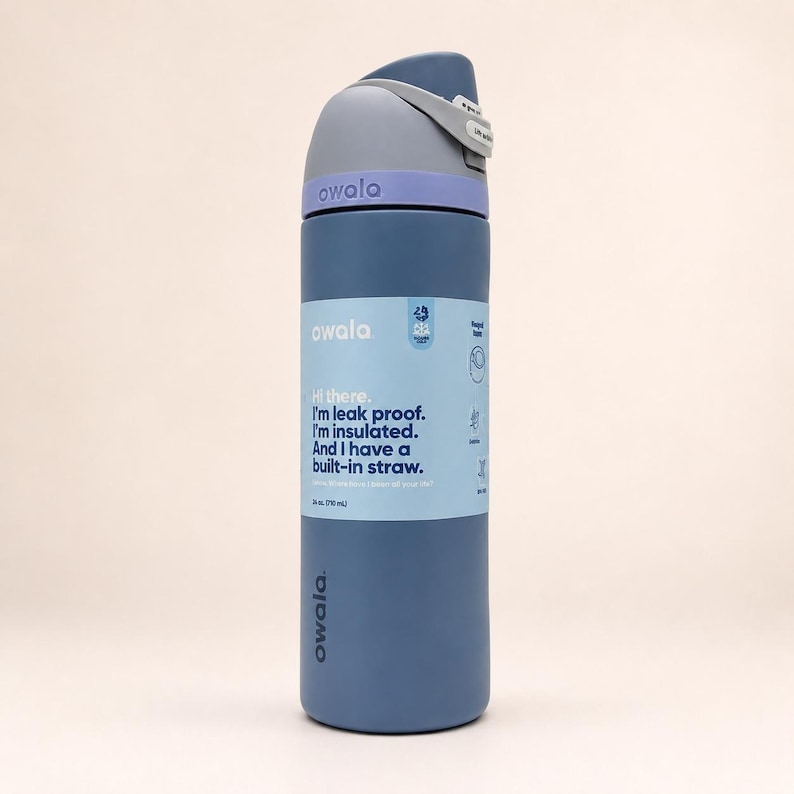 May include: A 24 oz. Owala water bottle in matte blue with a light purple collar and a dark gray lid featuring a built-in straw. The label reads: Hi there. I'm leak proof. I'm insulated. And I have a built-in straw. It also displays 24 oz. (710 mL).
