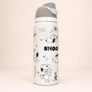 Pu&ograve; includere: Una borraccia Owala bianca con coperchio grigio e manico per il trasporto. La bottiglia &egrave; decorata con varie illustrazioni in bianco e nero di Snoopy e Woodstock, insieme a piccole stelle colorate, ciliegie e il testo SNOOPY e Owala.