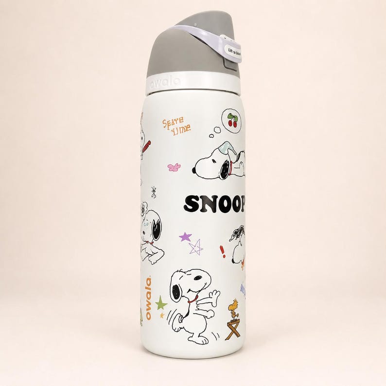 Pu&ograve; includere: Una borraccia Owala bianca con coperchio grigio e manico per il trasporto. La bottiglia &egrave; decorata con varie illustrazioni in bianco e nero di Snoopy e Woodstock, insieme a piccole stelle colorate, ciliegie e il testo SNOOPY e Owala.