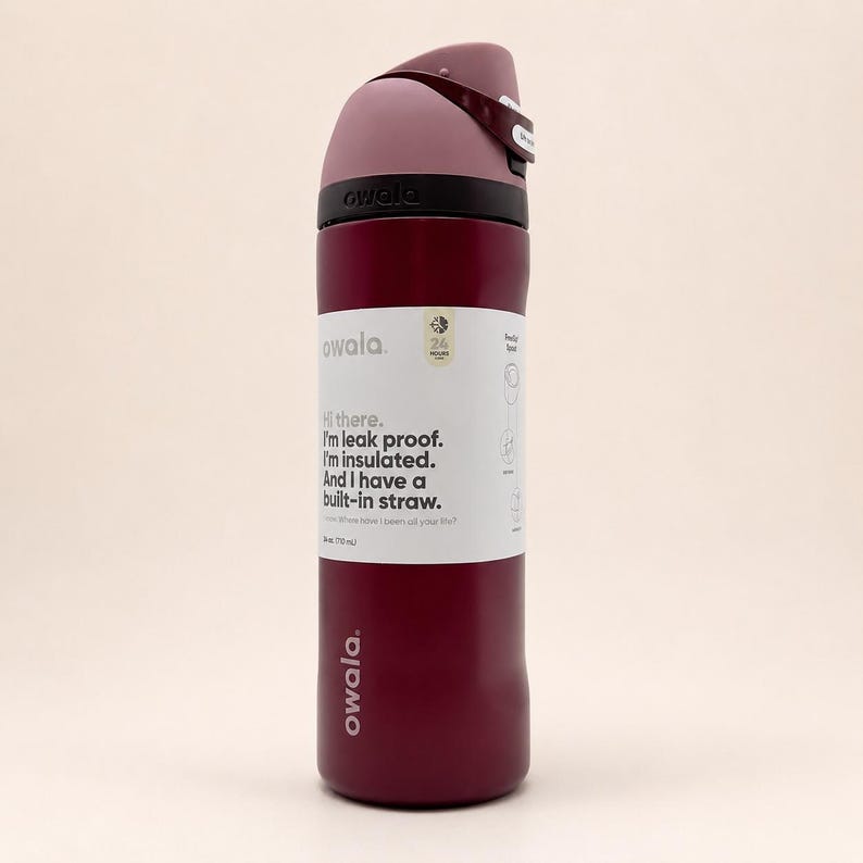 May include: A dark red Owala water bottle with a mauve lid and a built-in straw. The bottle features a white label with the text: Hi there. I'm leak proof. I'm insulated. And I have a built-in straw. The label also indicates a 24-ounce capacity.