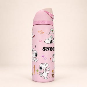 May include: A light pink Owala water bottle featuring Snoopy graphics, the text "SNOOPY" in bold black letters, and the phrase "Spare time" in orange. The bottle has a matching pink lid with a beige push-button mechanism and a carry handle.