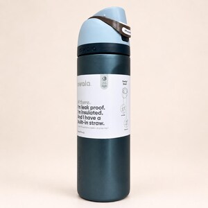 May include: A dark teal insulated water bottle with a light blue and brown lid. The bottle features a white label with the text: Hi there. I'm leak proof. I'm insulated. And I have a built-in straw. It also displays 24 hours cold and 24 oz (710 ml).