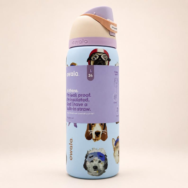 May include: A light blue Owala water bottle with a 24-ounce capacity, featuring a wrap-around label with text and dog illustrations. The bottle has a lavender and beige lid with a built-in straw, and the label reads: Hi there. I'm leak proof.