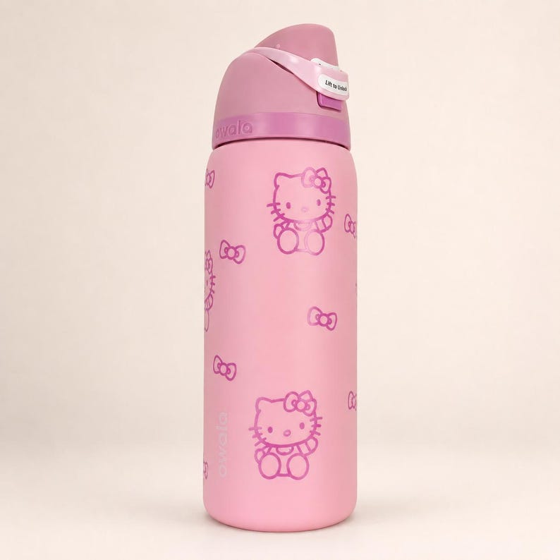 K&ouml;nnte beinhalten: Eine hellrosa Owala-Trinkflasche mit einem sich wiederholenden Muster aus Hello Kitty-Figuren und kleinen Schleifen in einem dunkleren Rosaton. Die Flasche hat einen rosa Deckel mit Klappmechanismus und einem wei&szlig;en Etikett mit der Aufschrift Lift to Sip.