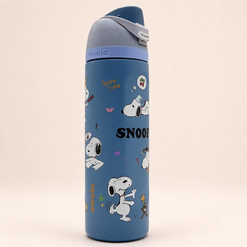 May include: A blue Owala water bottle featuring a Snoopy graphic print with the text "Spare Time" and "SNOOP". The bottle has a dark blue lid with a light blue collar, a carry loop, and a push-button mechanism for the spout, showcasing various Snoopy poses.