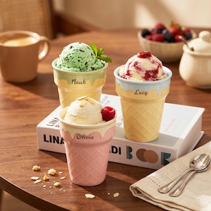Può includere: Tre coppette gelato a forma di cono waffle, ognuna con un diverso gusto di gelato. Una ha gelato alla menta e cioccolato, una vaniglia con un lampone e una con un vortice di frutti di bosco rossi. Ogni coppetta ha un nome.