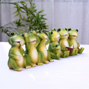 Peut inclure: Six figurines de grenouilles vertes et jaunes. Certaines grenouilles se couvrent les yeux, les oreilles ou la bouche, tandis que d'autres tiennent un livre ou un petit objet bleu. Les figurines ont des yeux noirs et une bouche rouge.