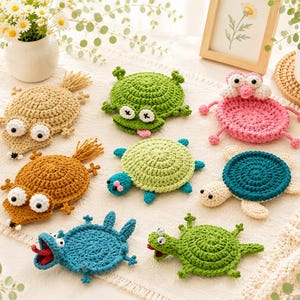 May include: A collection of eight handmade crochet animal coasters featuring various designs including turtles, frogs, and other creatures in shades of green, blue, pink, tan, and brown, each with distinct eyes and limbs arranged on a textured surface.