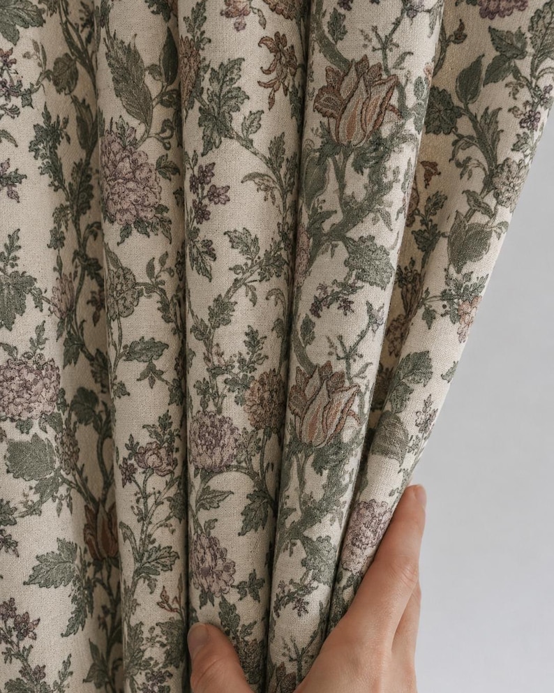 May include: A curtain panel featuring a dense botanical print on a light beige background. The fabric displays intricate floral patterns in muted shades of sage green, dusty rose, and brown, with detailed leaves and blossoms covering the surface.