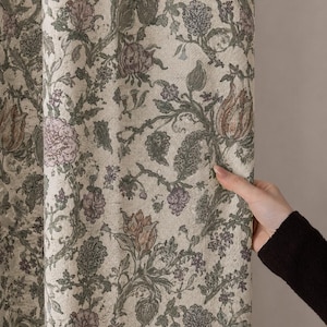 May include: A fabric curtain featuring a dense, intricate botanical pattern with muted green vines, sage leaves, and soft mauve floral blossoms set against a light cream-colored background. The textile displays a textured, woven appearance.