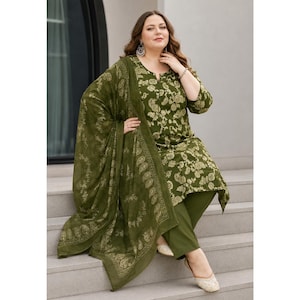 May include: An olive green three-piece outfit consisting of a long-sleeved tunic with a white floral and paisley print, matching solid olive green trousers, and a large, coordinating olive green shawl featuring a detailed white paisley border pattern.
