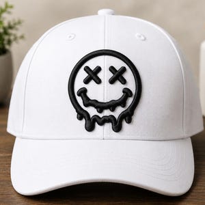 May include: A white baseball cap featuring a black embroidered graphic of a melting smiley face with X-shaped eyes. The design is centered on the front panel of the cap, which has a structured crown, a curved brim, and a button on the top.