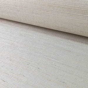Op de afbeelding: Een rol gebroken wit textiel met een duidelijke horizontale slub-textuur. Het materiaal vertoont een geweven uiterlijk met zichtbare vezels en een consistente lichtbeige tint over het gehele oppervlak, met een strak verweven rasterpatroon.