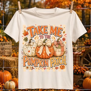 Könnte beinhalten: Ein cremefarbenes Kurzarm-T-Shirt mit einer Grafik von drei Kürbissen mit Schleifen und dem Text "TAKE ME TO THE PUMPKIN PATCH" in orangefarbener und brauner Schrift, akzentuiert durch kleine Herbstblätter und Blumen auf hellem Grund.