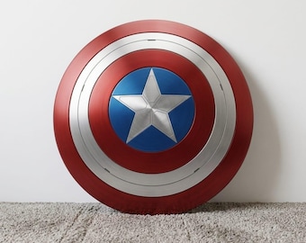 Può includere: Uno scudo rotondo con un anello esterno rosso, un anello centrale argentato e un centro blu con una stella argentata. Lo scudo è una replica dello scudo di Captain America.
