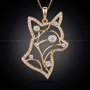 May include: A gold pendant shaped like a stylized fox head, featuring an openwork design outlined with small pavé-set clear stones. The fox silhouette includes several larger, round, brilliant-cut clear stones set within the frame.