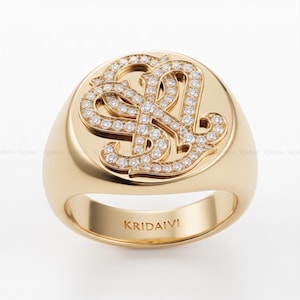 Könnte beinhalten: Ein polierter goldener Siegelring mit einem erhabenen, kreisförmigen Mittelstück, das mit einem pavé-gefassten Diamant-Monogramm der Buchstaben S und L verziert ist. Das innere Ringband ist deutlich mit dem Markennamen KRIDAIVI graviert.