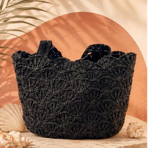 May include: A black crochet tote bag featuring a repeating fan-shaped stitch pattern throughout the body. The bag has an open top design with two integrated handles and a textured, woven appearance created by the dark yarn construction.