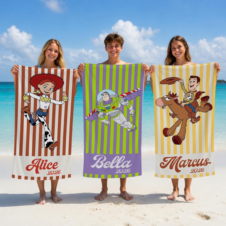 May include: Three rectangular beach towels featuring Toy Story characters. The left towel has brown stripes and Jessie, the center has green and purple stripes with Buzz Lightyear, and the right has yellow stripes with Woody on Bullseye. Names and 2026 are printed.
