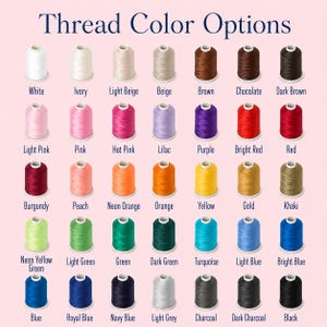 May include: A grid of 35 spools of thread arranged in five rows and seven columns, each labeled with its color name. The colors include white, ivory, beige, brown, pink, red, orange, yellow, green, blue, grey, and black shades.