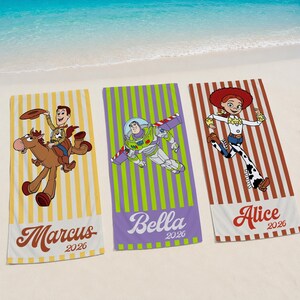 May include: Three rectangular beach towels featuring Toy Story characters. The left towel is yellow-striped with Woody riding Bullseye and the name Marcus 2026. The center towel is green-striped with Buzz Lightyear and the name Bella 2026. The right towel is brown-striped with Jessie and the name Alice 2026.