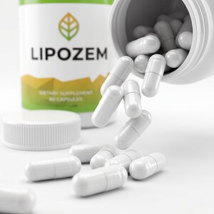 May include: White capsules spilling from a white bottle labeled "LIPOZEM". The bottle has a green and yellow label with a leaf design. The capsules are scattered on a white surface, with the bottle cap visible.