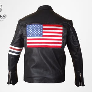 Op de afbeelding: Zwarte leren jas met een Amerikaanse vlag op de rug. De jas heeft een opstaande kraag, mouwen met ritssluiting en rood-wit-blauwe strepen op de linkermouw. Een klassiek ontwerp, deze jas is een stijlvolle buitenkleding.