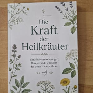 Peut inclure: Un livre intitulé "Die Kraft der Heilkräuter" avec des illustrations botaniques d'herbes et de fleurs. La couverture présente du texte en allemand, avec un sous-titre sur les applications naturelles et les recettes pour une pharmacie maison.