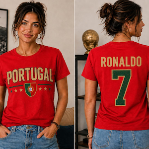 May include: A red short-sleeve t-shirt featuring the word PORTUGAL in gold letters above a small Portuguese flag emblem and four gold stars on the front. The back displays the name RONALDO in gold letters above a large green number 7.