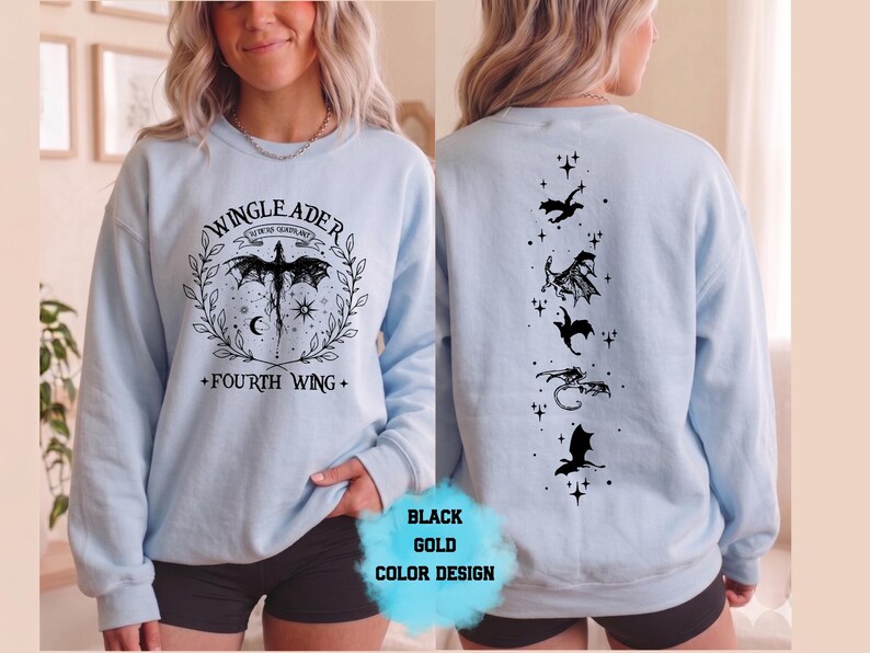 May include: Light blue sweatshirt with a black dragon graphic on the front and back. The front features the text "WINGLEADER" and "FOURTH WING". The back has a vertical design of black dragons and stars.