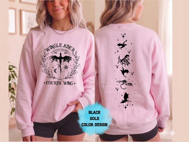 May include: A light pink sweatshirt with black dragon graphics. The front features a dragon design with the text "WINGLEADER" and "FOURTH WING". The back has a vertical line of dragon silhouettes. The design is in black and gold.