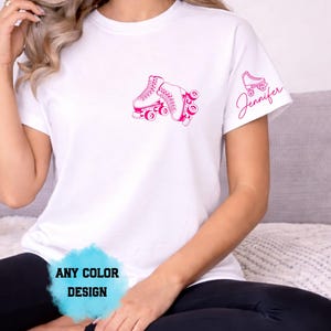 May include: White t-shirt with a pink roller skate graphic on the front and a smaller roller skate and the name "Jennifer" on the sleeve. The text "ANY COLOR DESIGN" is at the bottom.